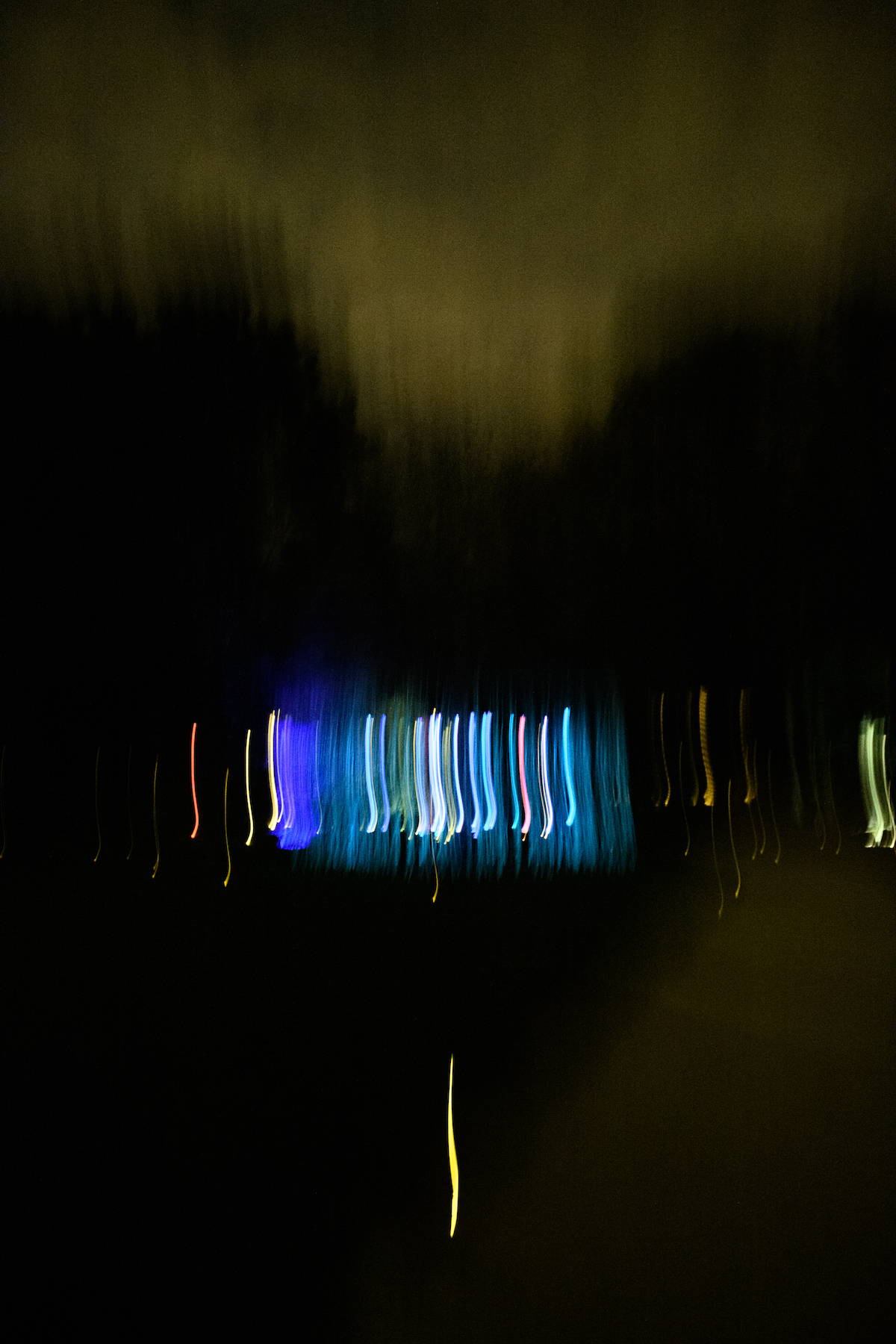 Blackout — traînées lumineuses colorées issues d’un mouvement prolongé, sur fond sombre