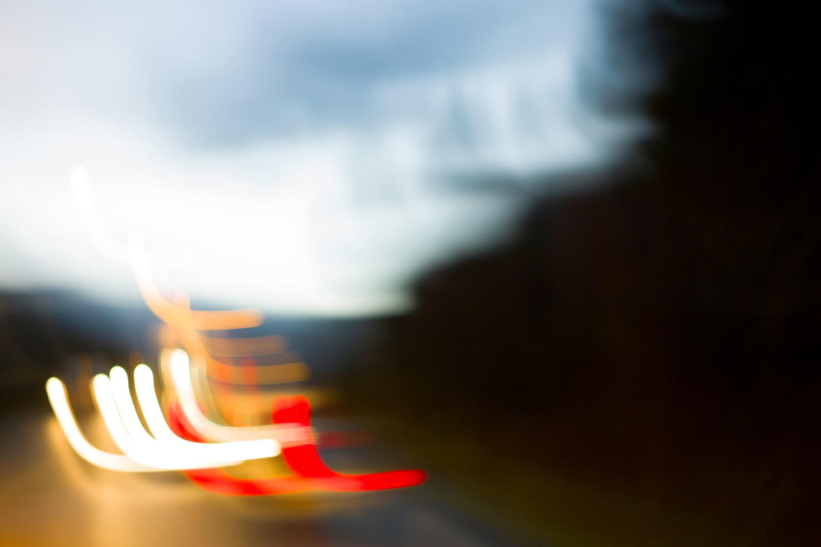 Blackout — traînées lumineuses blanches et rouges dans un paysage nocturne flou (image 06)